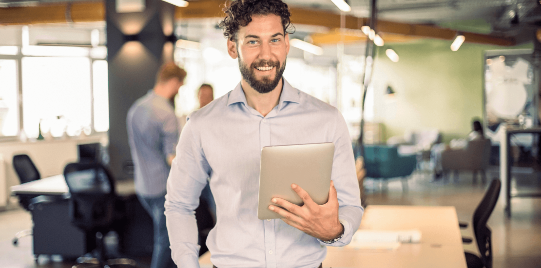 Hombre con una tablet en la mano y de fondo una oficina